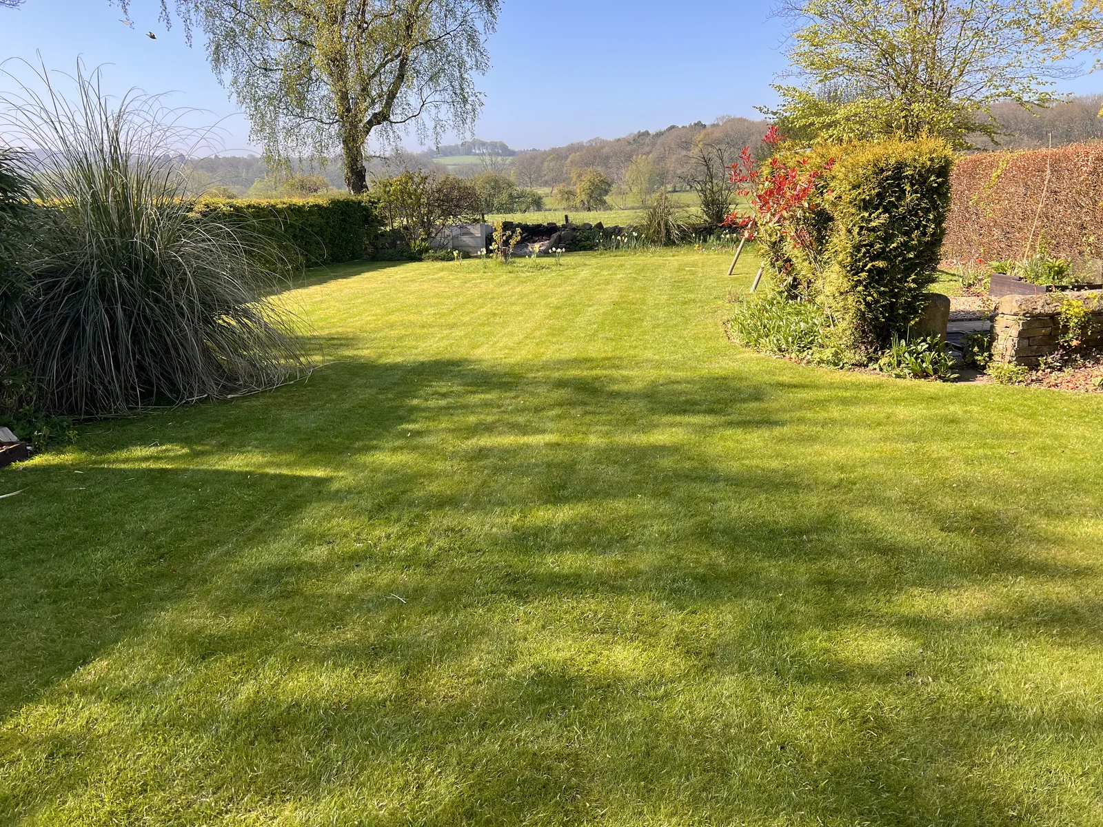 Striped lawn with countryside views and colourful borders, North Leeds